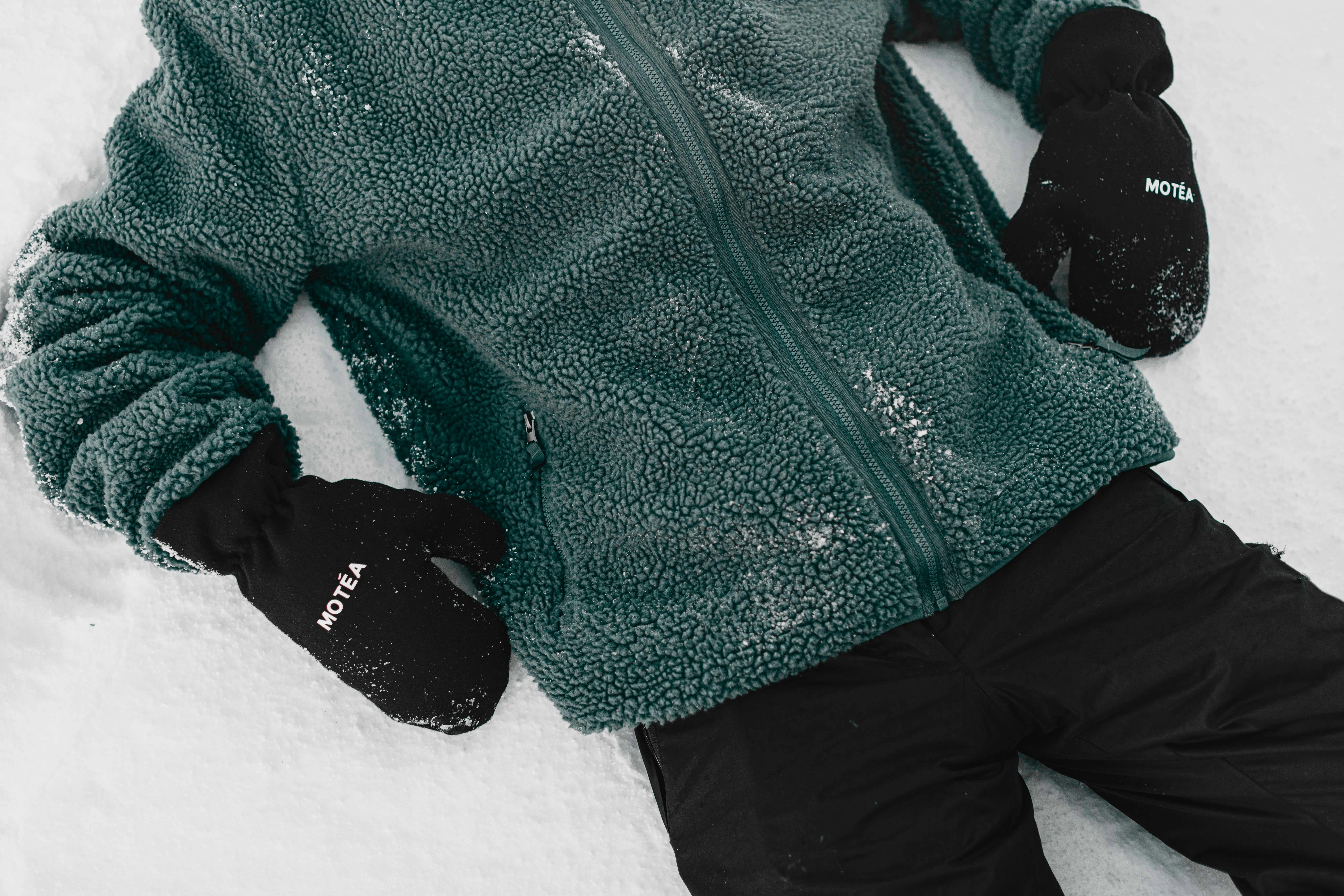 Prescription Goggle Inserts - A person in a green fleece jacket and black gloves resting on snow in Brezovica, Serbia.