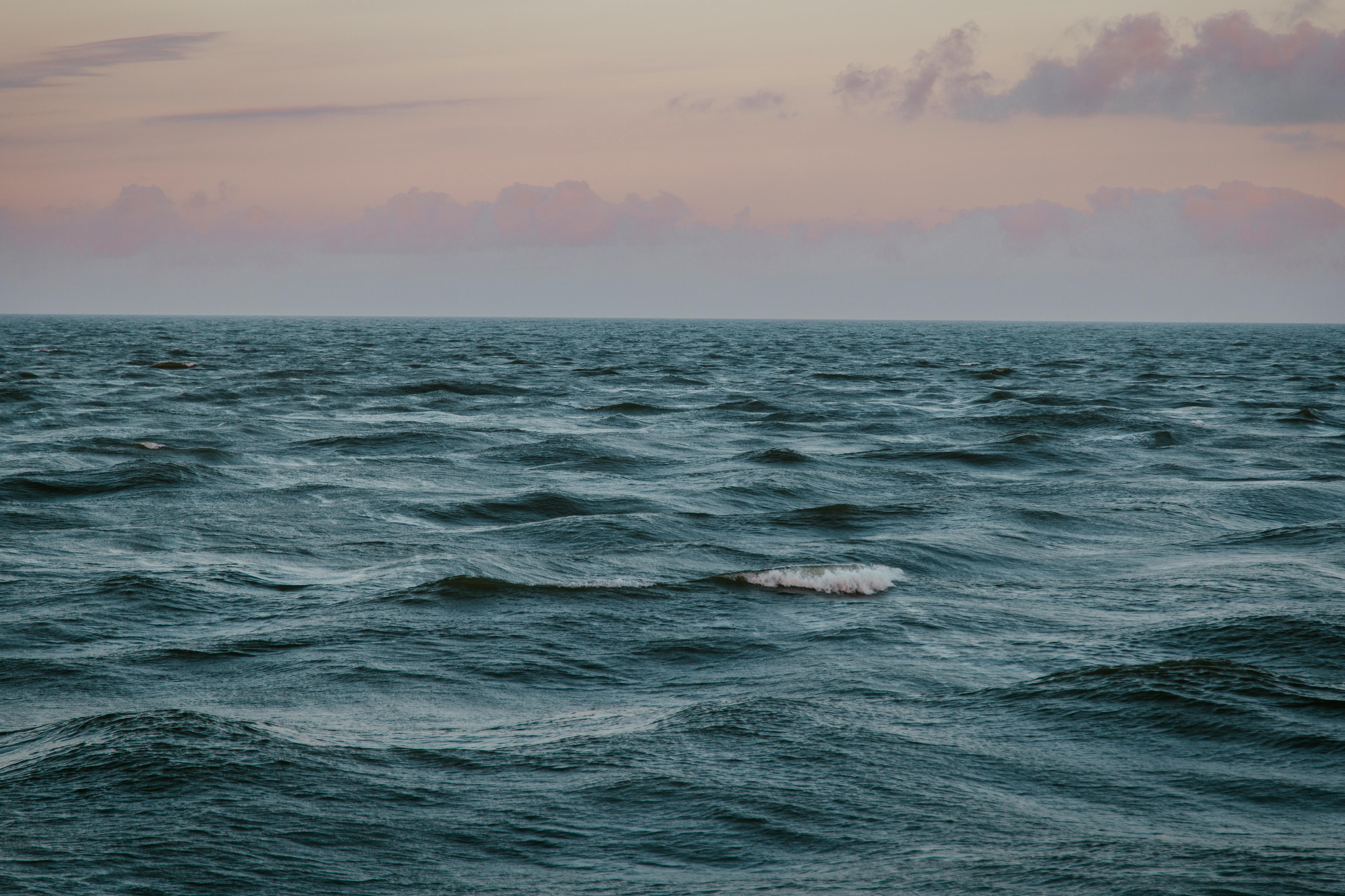 日落时分，宁静的海浪在安详的天空下，展现着自然的平和