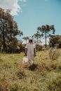 Women Standing on the Grass While Holding a Bucket