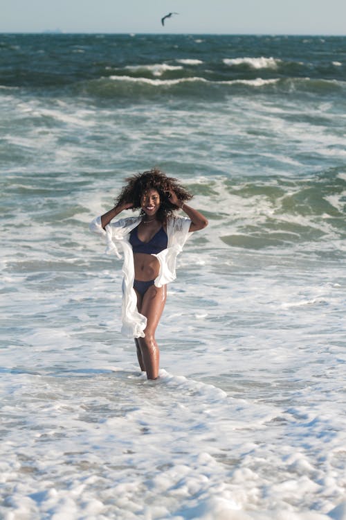 Free Photo of Smiling Woman in Bikini Posing By The Beach Stock Photo
