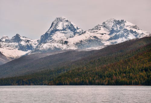 A mountain range with snow capped peaks in the distance