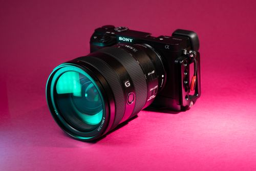 Free Sony camera and lens on a striking pink background, ideal for photography enthusiasts. Stock Photo