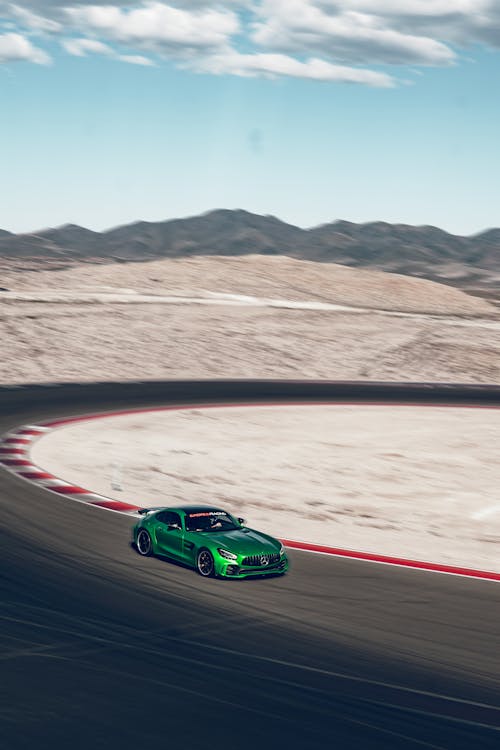 A green sports car driving on a track