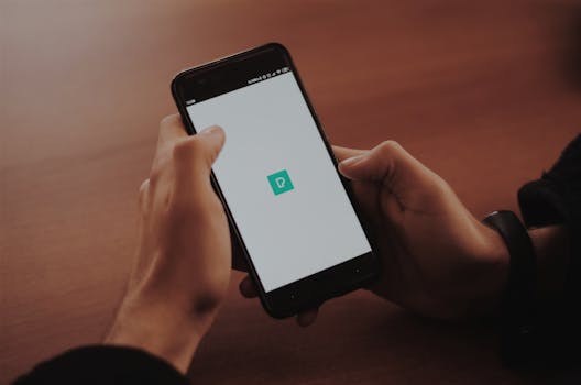 在舒适的室内环境中，手持智能手机的人展示着一块带有徽标的空白屏幕