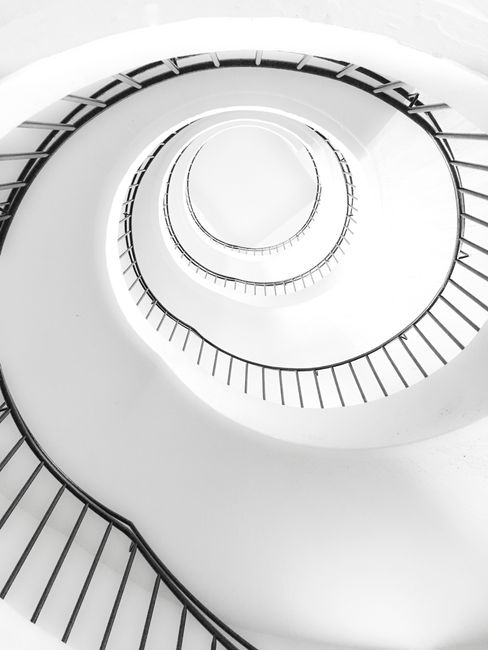 A mesmerizing black and white abstract view of a spiral staircase in Munich, showcasing minimalist design.