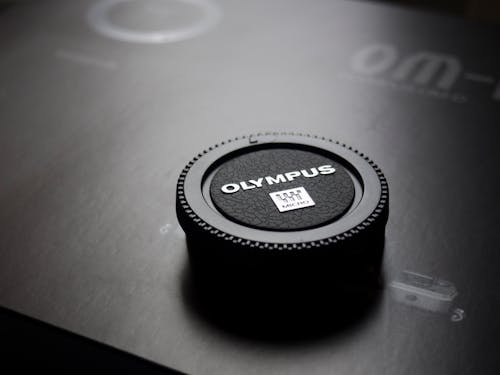 Free Olympus Camera Lens Cap Placed on Box Stock Photo
