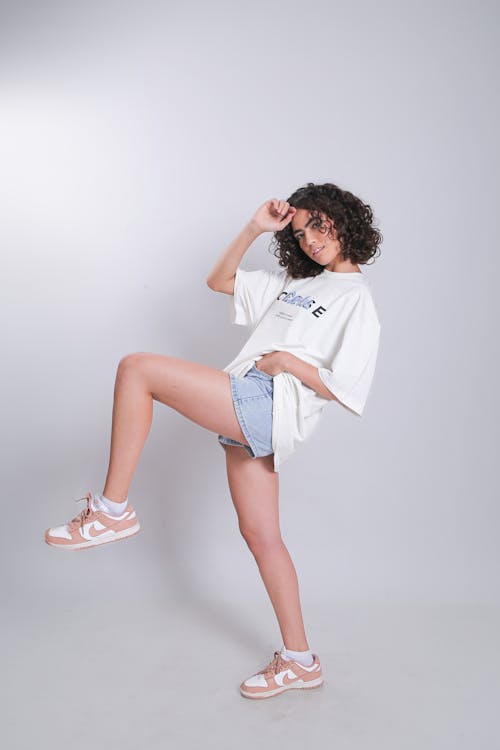 A woman in shorts and a t - shirt posing