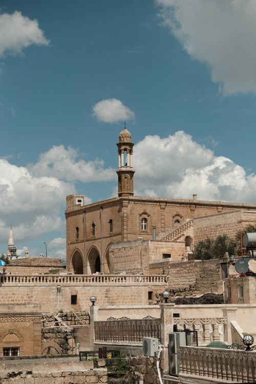 Free A historic building with a tower in Midyat, Turkey, standing under a vibrant blue sky. Stock Photo