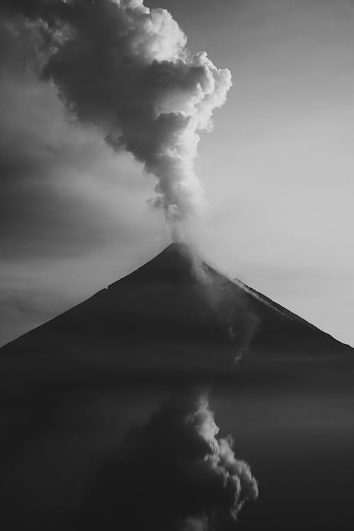 Black and white photo of volcano with smoke coming out