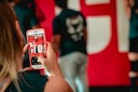 一名妇女在室内用智能手机记录活动瞬间