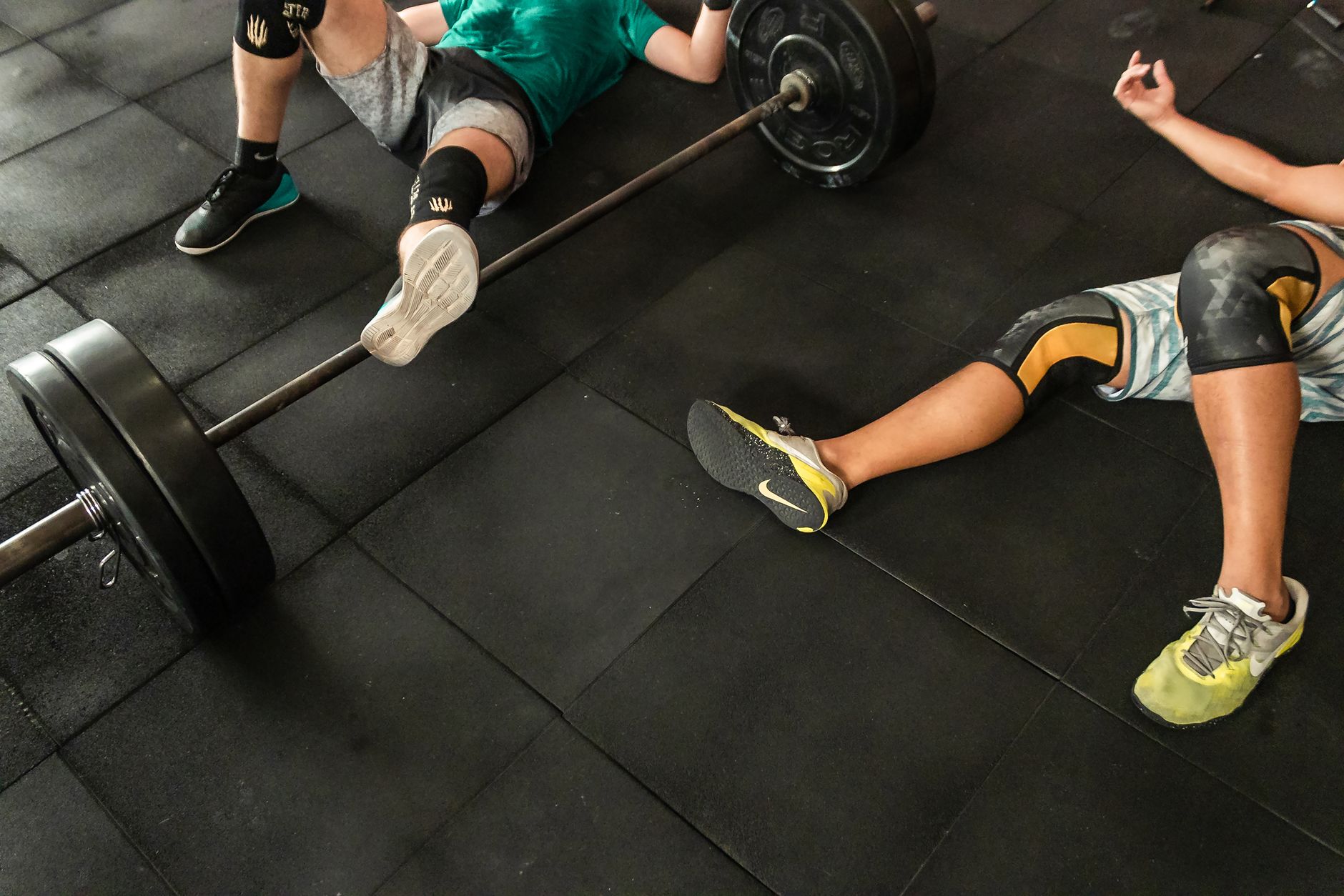 Athlete resting on gym mat after workout, highlighting the importance of recovery.