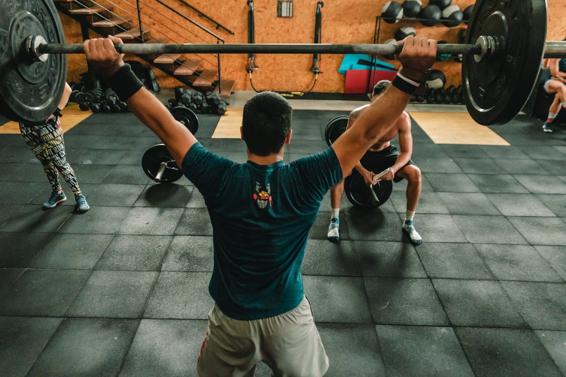 Person Lifting Barbell Indoors Stock Photo