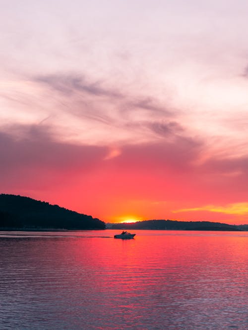 Free Boat in Middle of Body of Water during Sunset Stock Photo