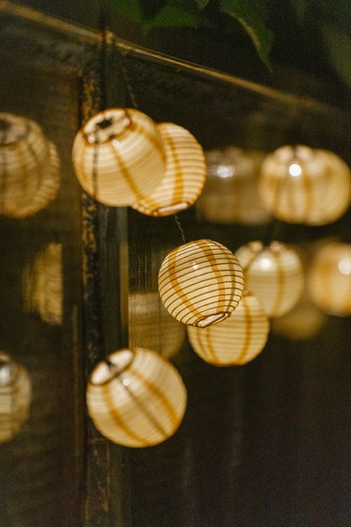 Free A close-up of warmly lit hanging lanterns creating an inviting atmosphere indoors. Stock Photo