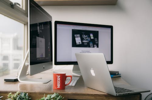 Free Silver Macbook on Top of Brown Wooden Table Stock Photo