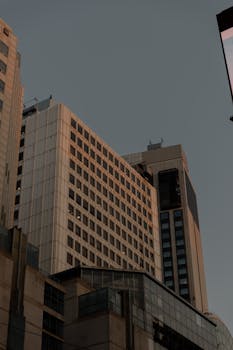 High-rise buildings with modern design under a twilight sky, showcasing urban architecture.