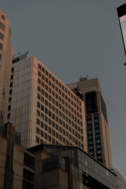 Free High-rise buildings with modern design under a twilight sky, showcasing urban architecture. Stock Photo