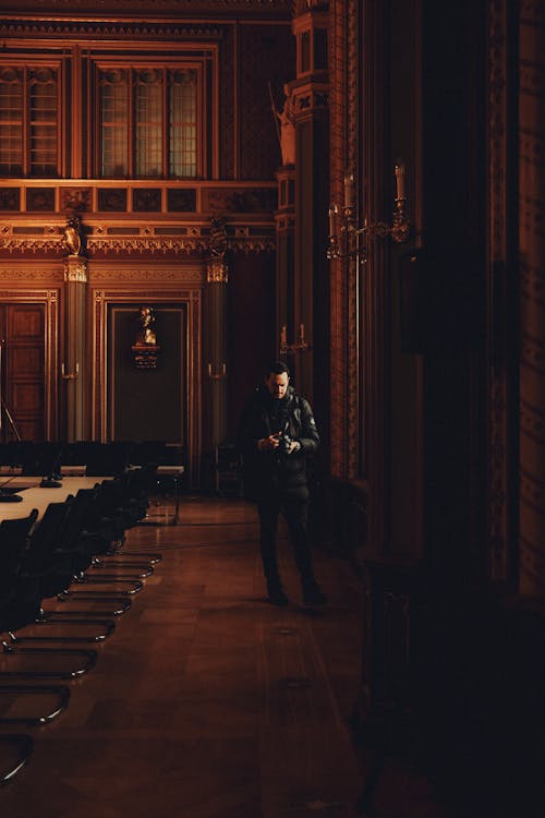 Man Walking with Camera in Vintage Hall