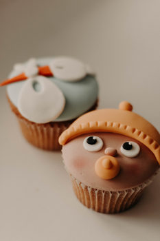 Charming cupcakes with fondant icing featuring playful cartoon faces, perfect for parties.