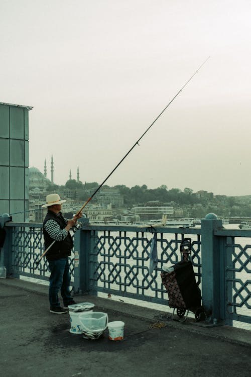 A man is fishing on a bridge
