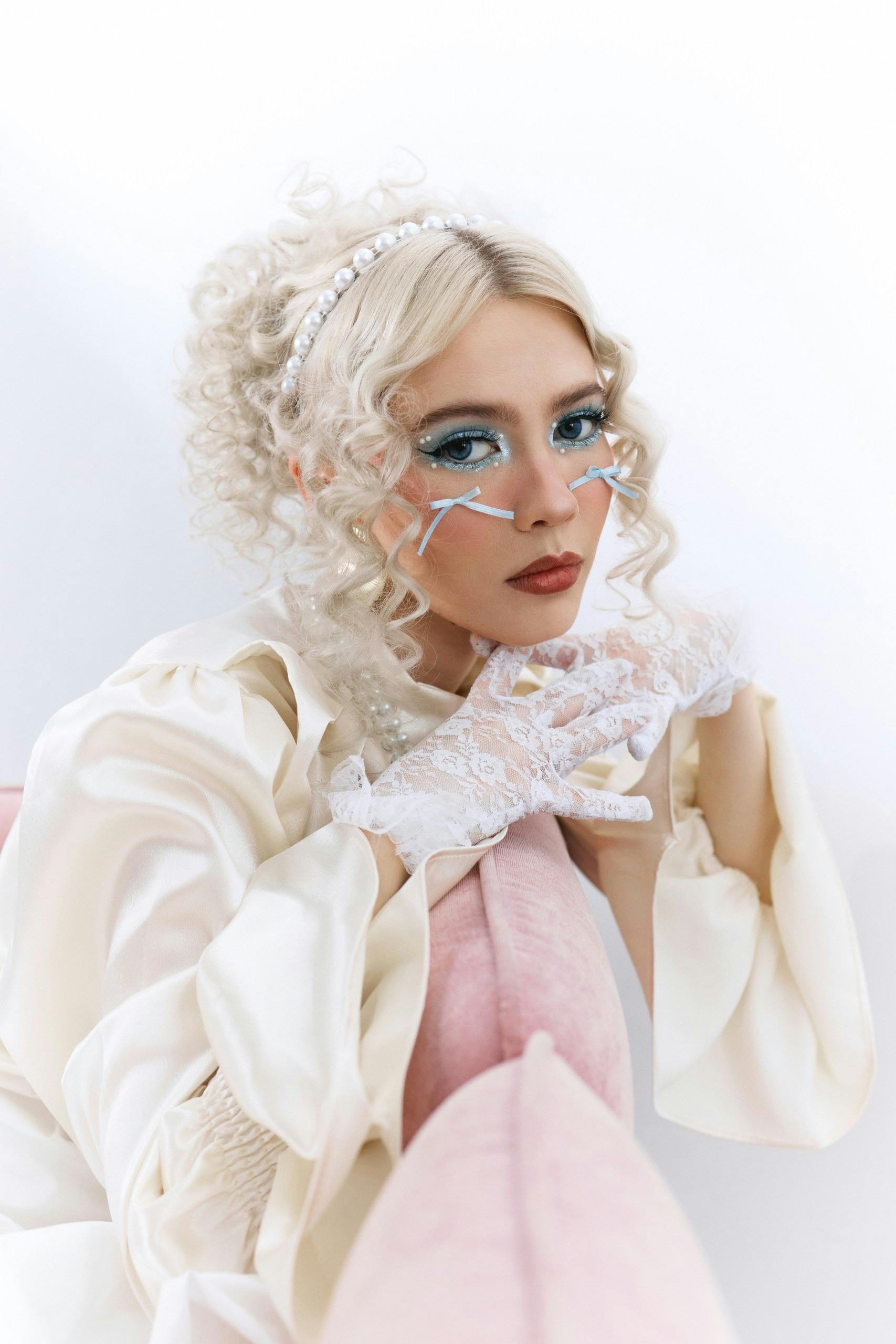 A stylish portrait of a woman in vintage fashion with lace gloves and glamorous makeup.