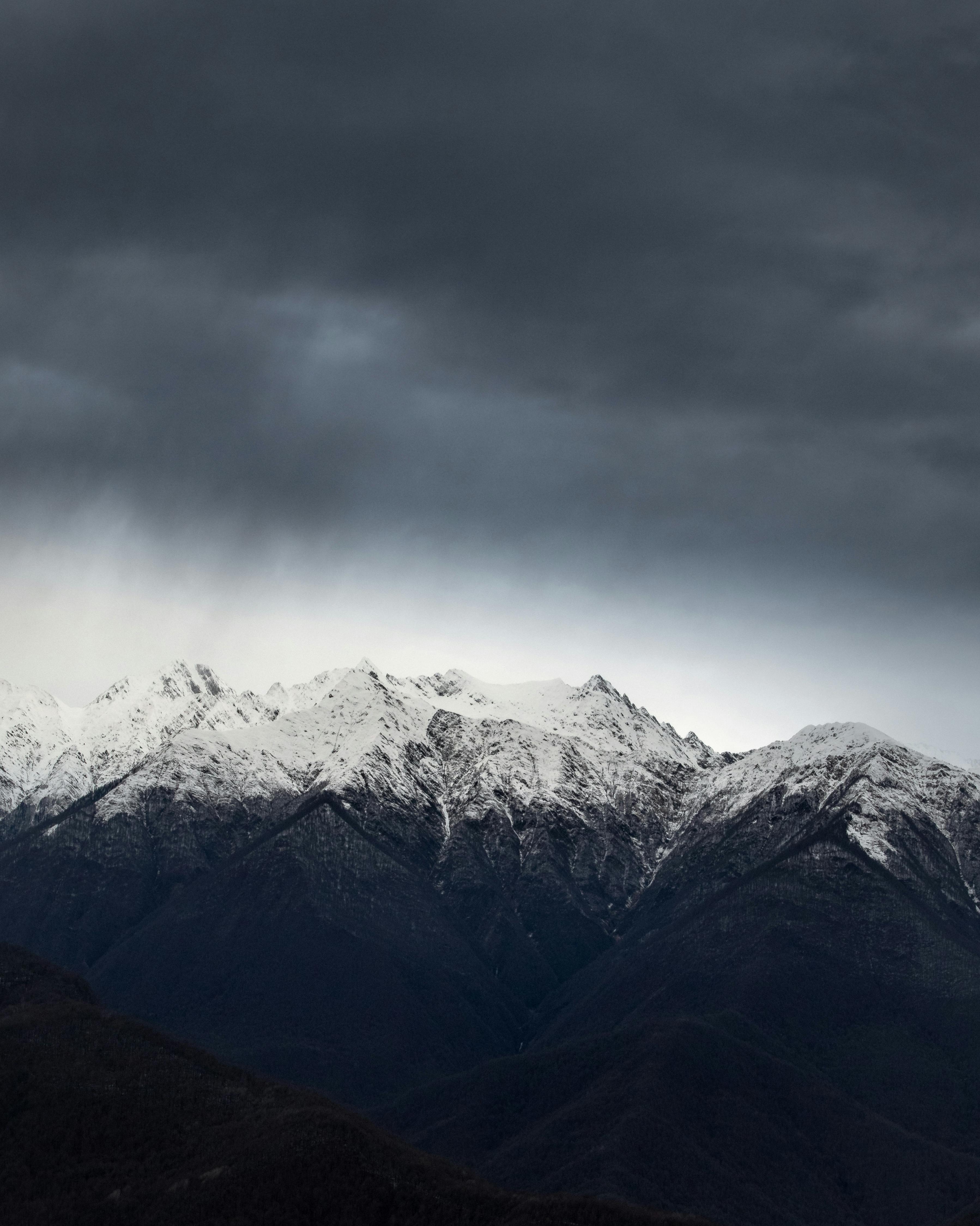俄罗斯索契，多云天空下积雪覆盖的山峰显得格外壮观