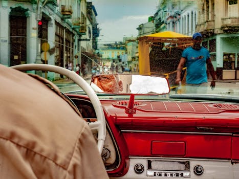 从里面看到一辆经典的汽车驶过古巴哈瓦那繁华的街道