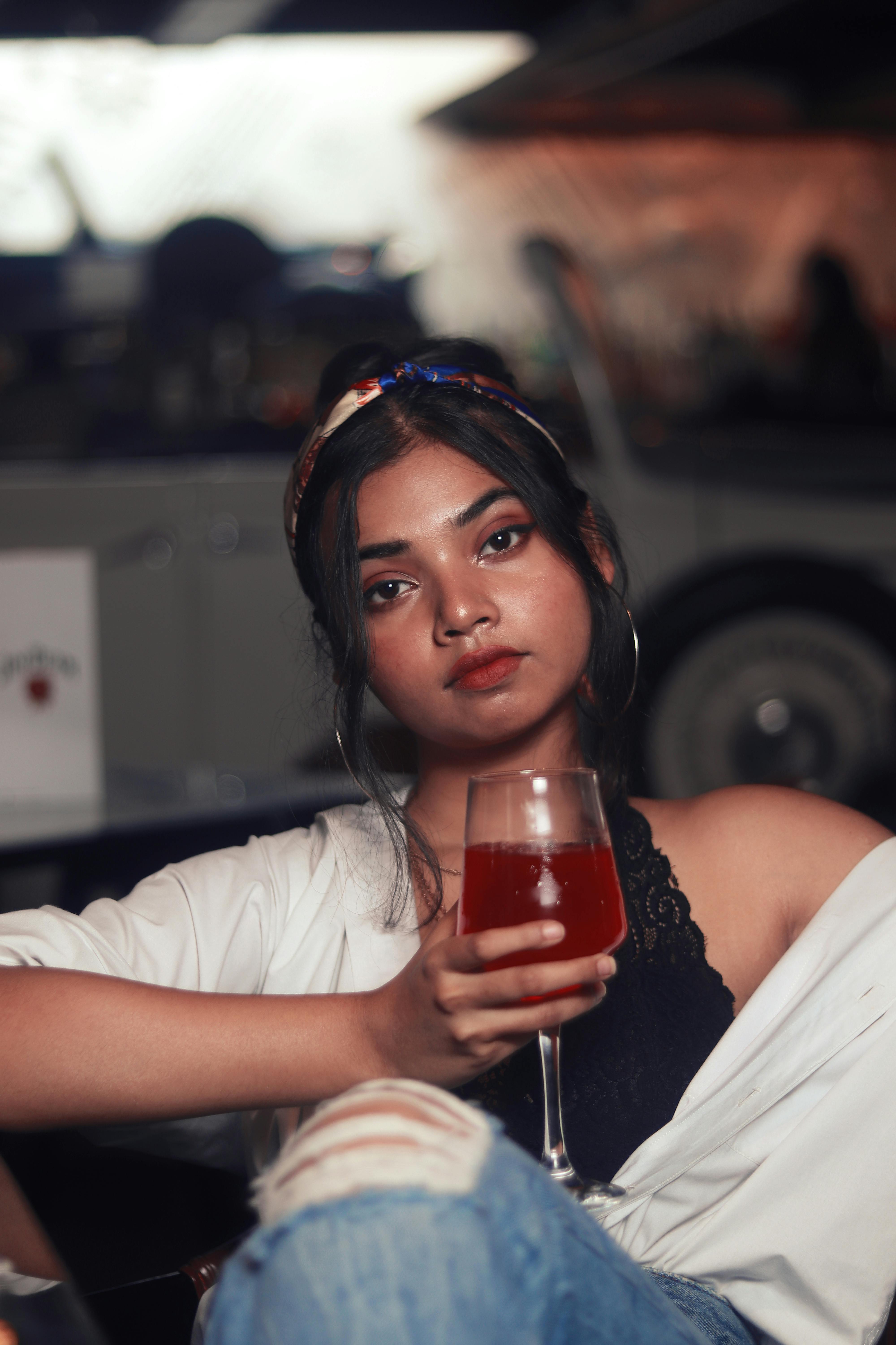 woman holding clear long stem wine glass