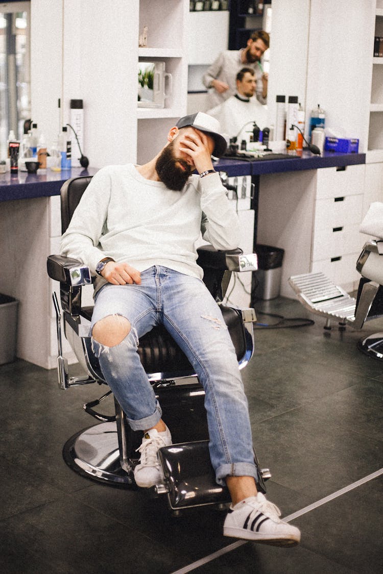 Man Sitting On A Barber's Chair