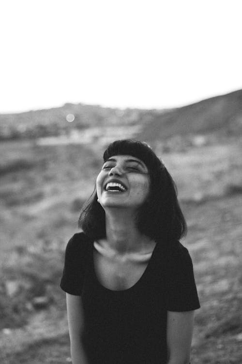 A black and white photo of a woman laughing