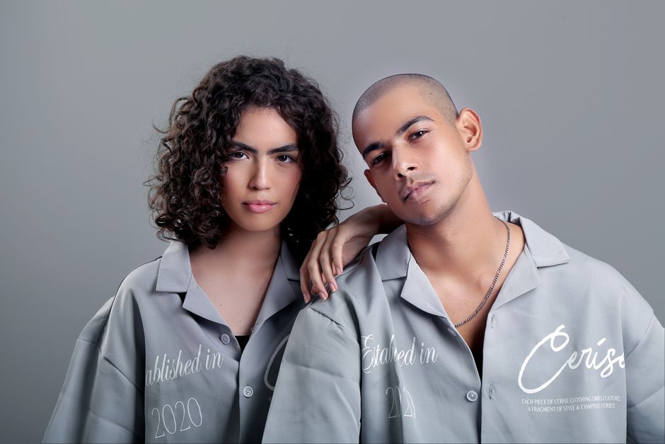 Modern portrait of two fashion models wearing matching gray outfits in a studio setting. Modern portrait of two fashion models wearing matching gray outfits in a studio setting.