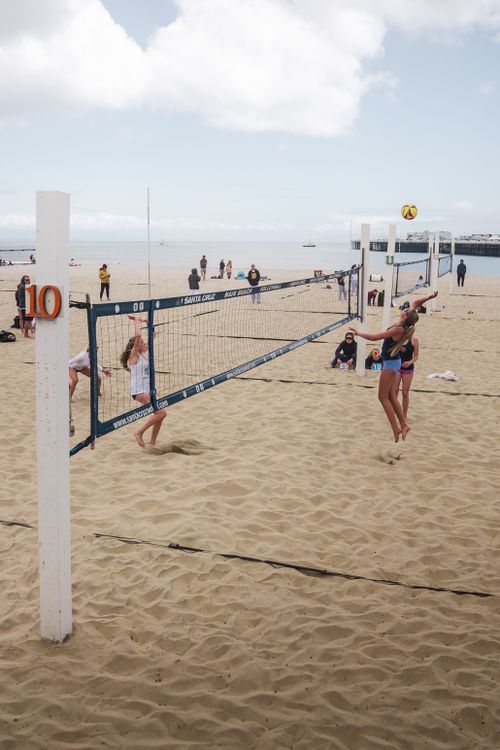 Free Dynamic beach volleyball game set against Santa Cruz's scenic shoreline. Stock Photo