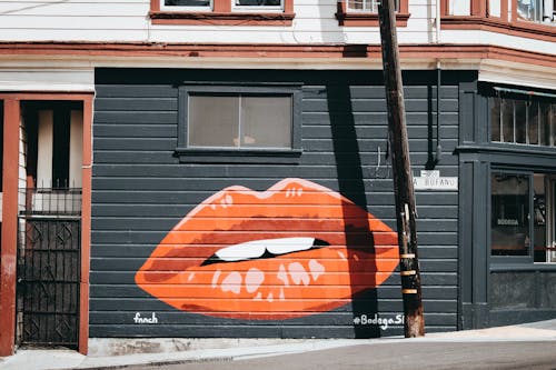 бесплатная Стена здания окрашена в черные и оранжевые губы Стоковое фото