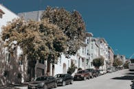 阳光明媚的日子里，在旧金山发现一条风景如画的街道，街道两旁是迷人的房屋和停放的汽车