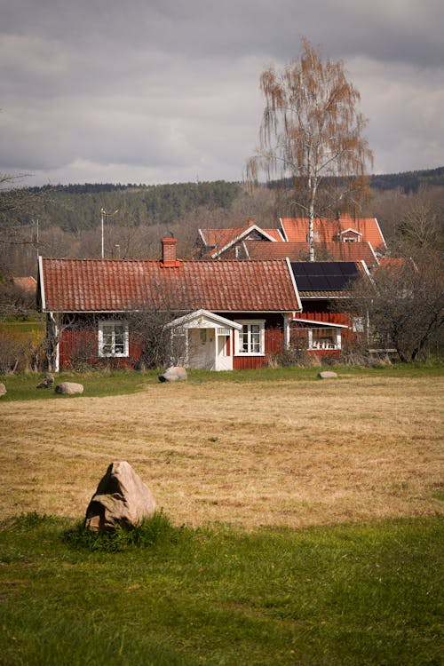 A red house in a field with a green grass