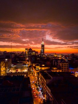 A breathtaking aerial view of Mexico City's skyline with the iconic Torre Latinoamericana during a vibrant sunset.
