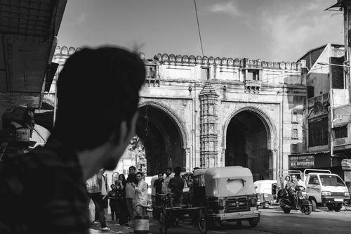 Free Historic Teen Darwaza Gate in bustling Ahmedabad with vehicles and pedestrians. Stock Photo