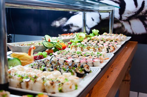 Free Sushi on White Plates on Brown Wooden Table Stock Photo