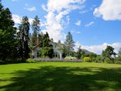 在明亮的蓝天下，田园诗般的乡村别墅被薰衣草和绿色植物环绕