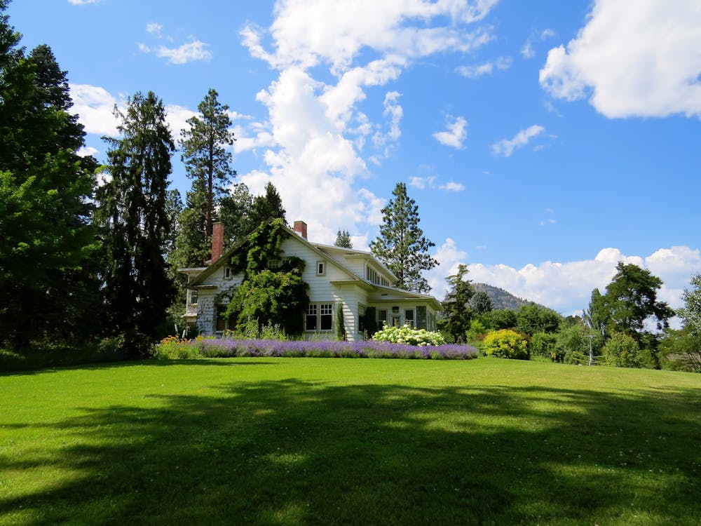 Free House Surrounded by Green Grass Below Clouds and Sky Stock Photo