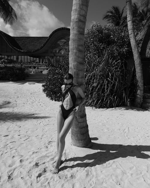 A woman in a bikini standing on a palm tree