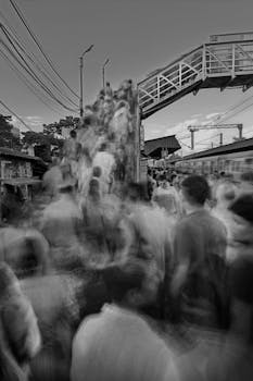 A dynamic black and white shot of people moving on a Kolkata footbridge.