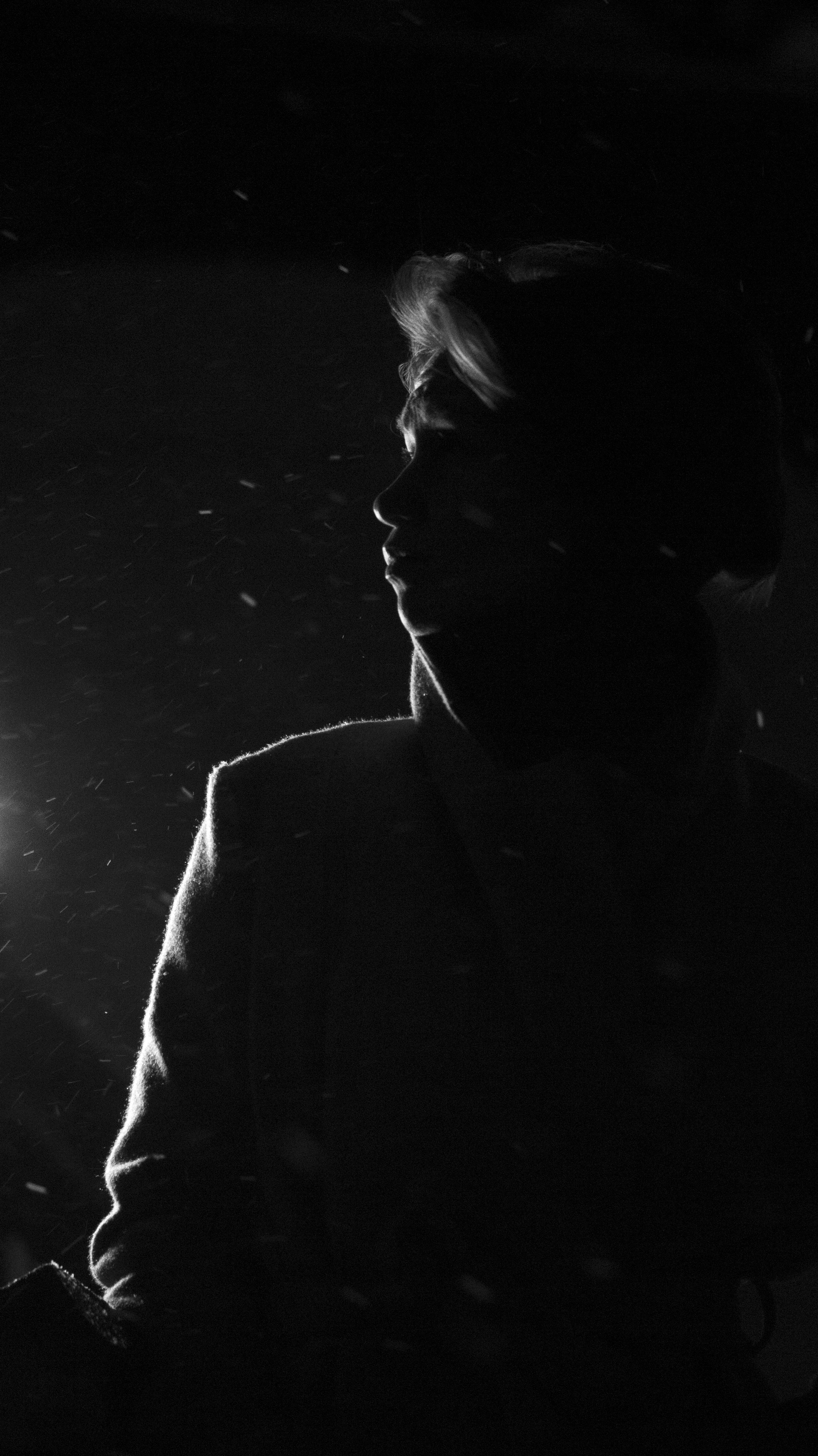 Artistic black and white silhouette of a woman in the dark, exuding mystery.