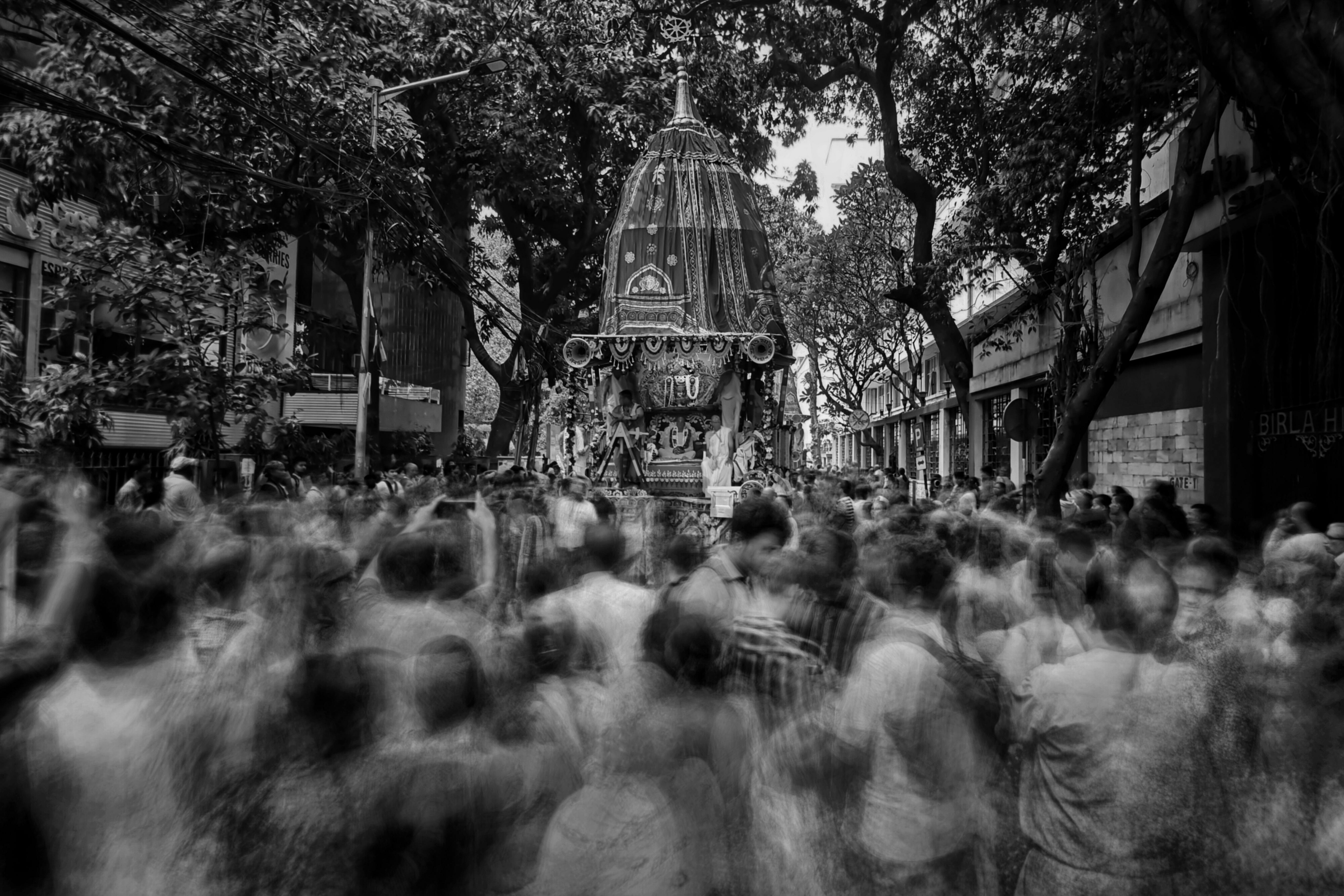 A dynamic street scene depicting a moving crowd during a festival procession in Kolkata.