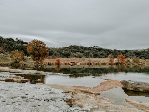 A lake with rocks and trees in the background