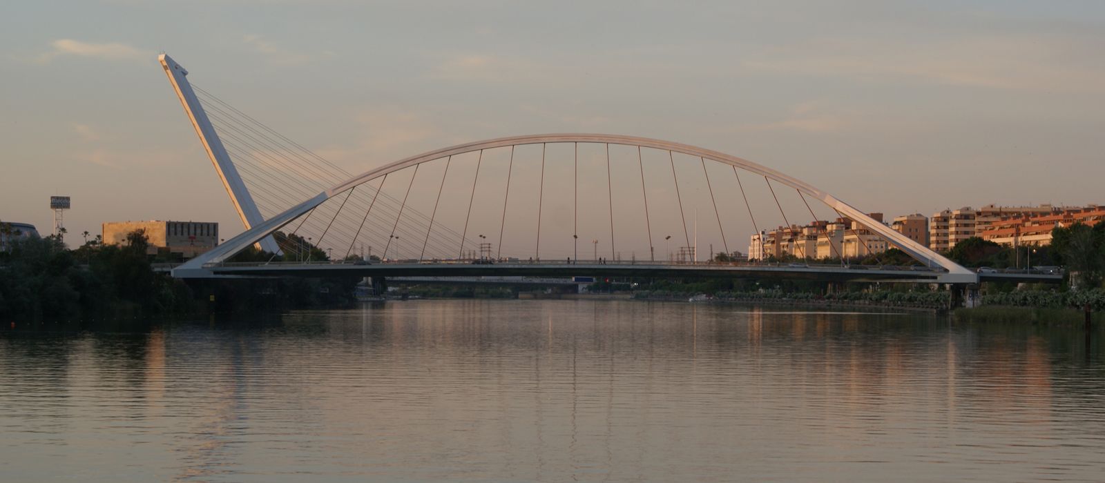 Stunning evening view of La Barqueta Bridge over river in Seville, Spain.