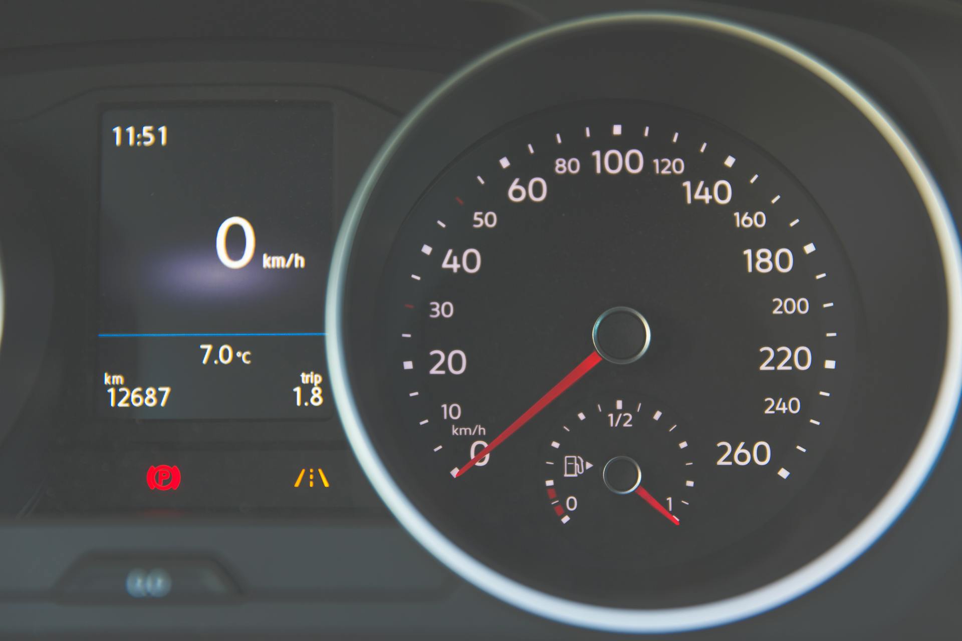 Detailed view of a car speedometer showing 0 km/h and fuel gauge with digital display.