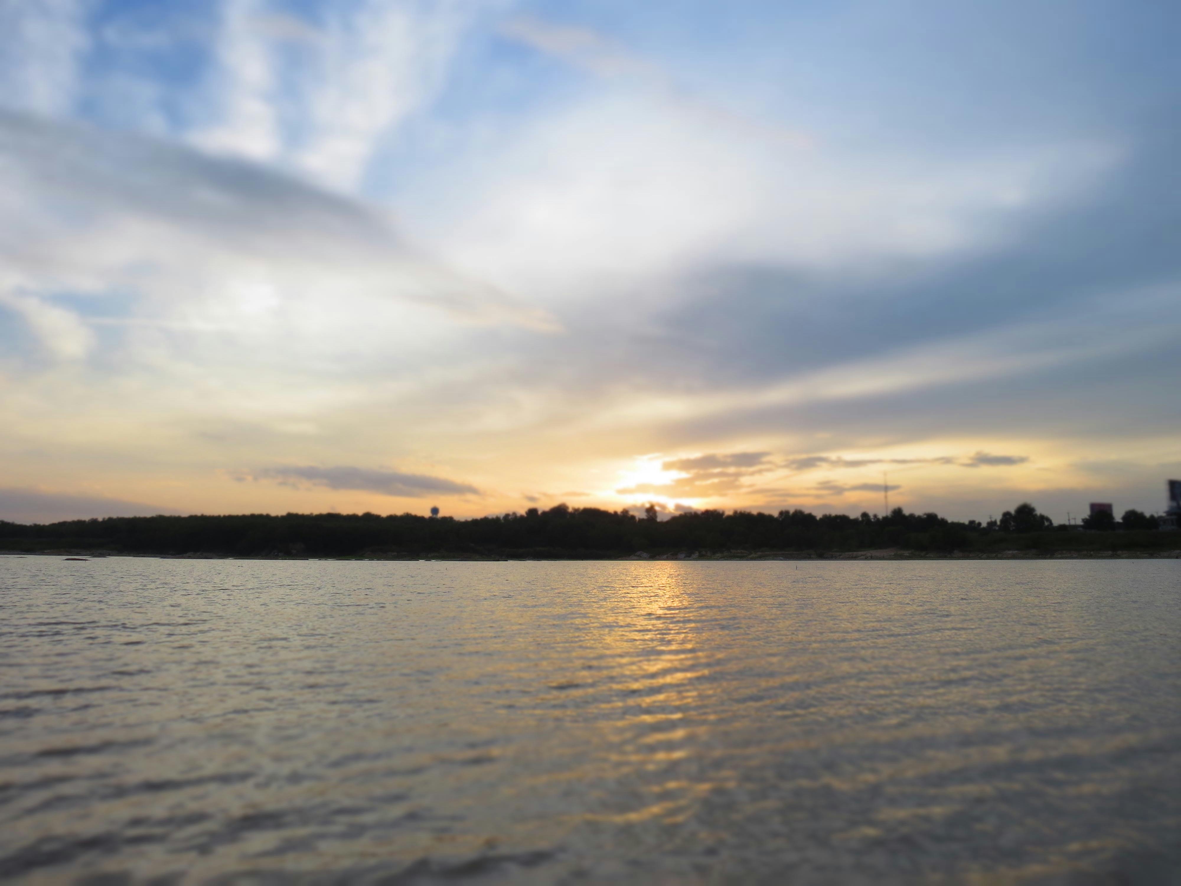 Concert crowd with hands raised, lights and stage in the background