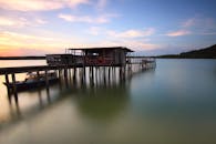 宁静的湖面上，日落静谧，质朴的码头旁船只缓缓移动