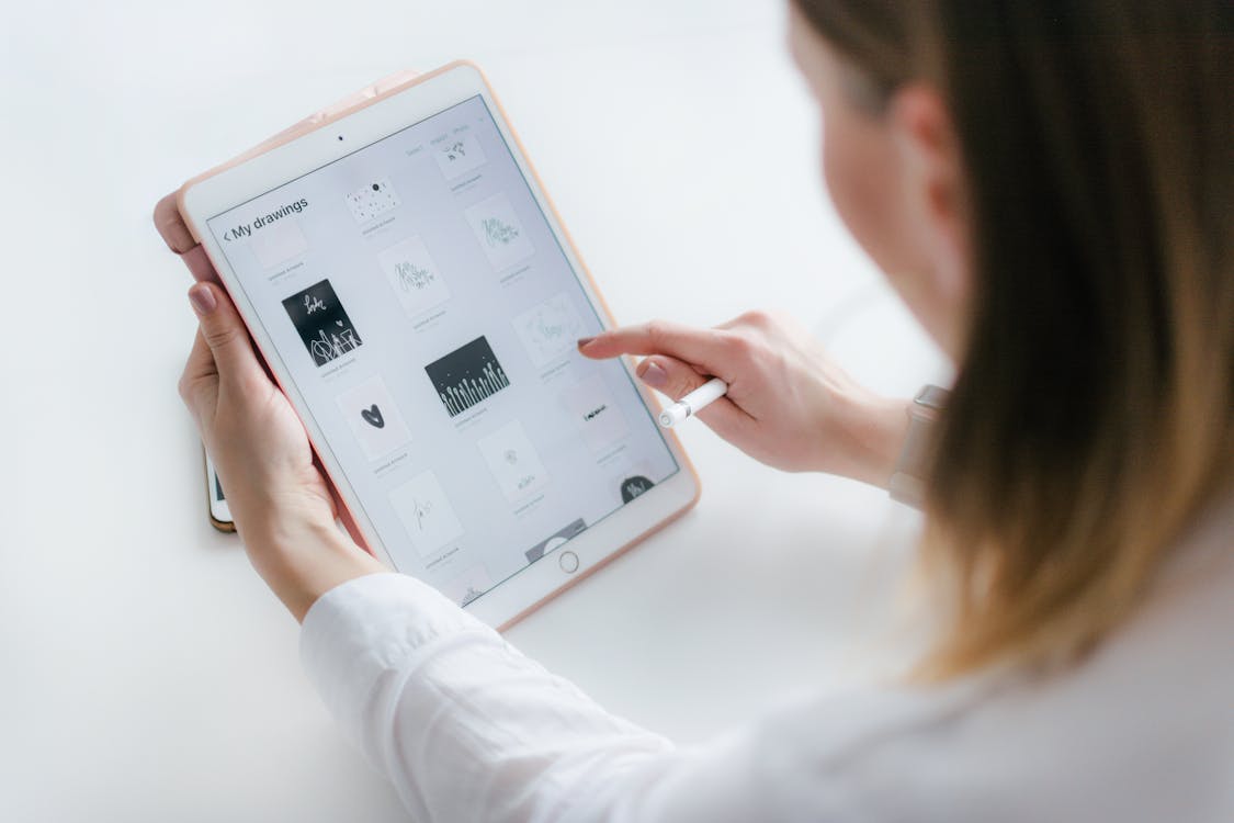 gratis Vrouw Zittend Naast Tafel Tijdens Het Gebruik Van Ipad Stockfoto